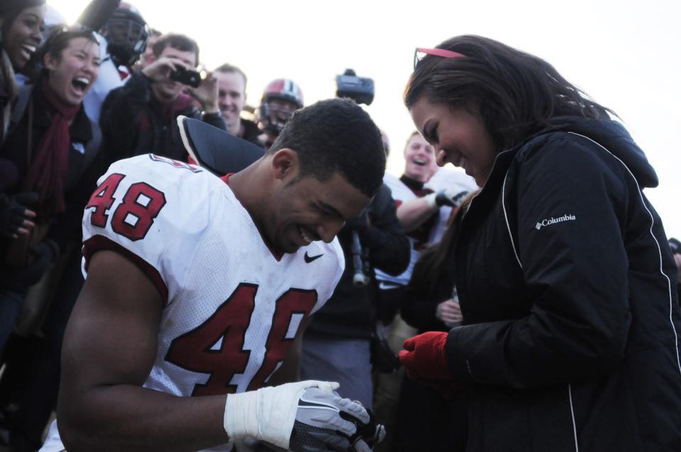 Senior defensive tackle Josue Ortiz proposes to Kayci Baldwin '14 at The Game on Saturday. Harvard won The Game, 45-7, to finish off a perfect Ivy League season.