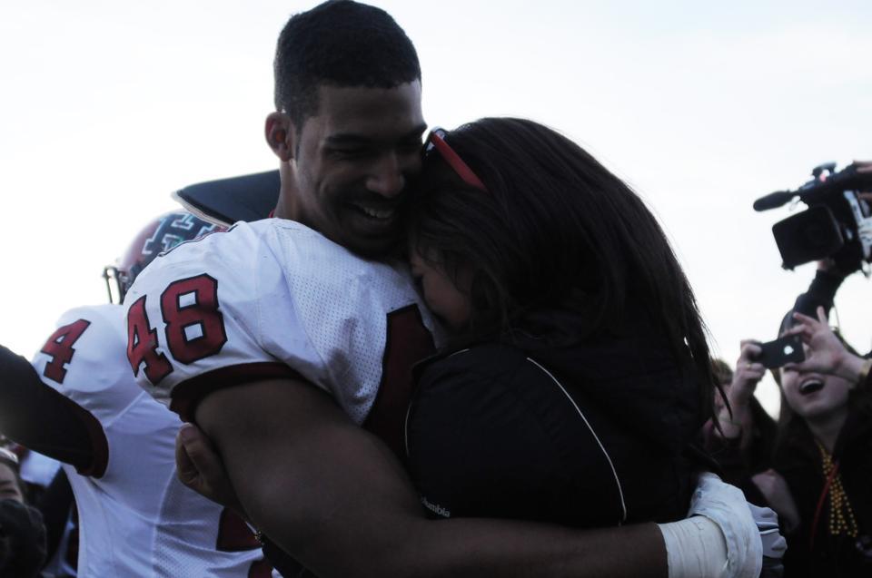 Kayci Baldwin '14 accepts Josue Ortiz's proposal at the end of Harvard's 45-7 win over Yale in New Haven.