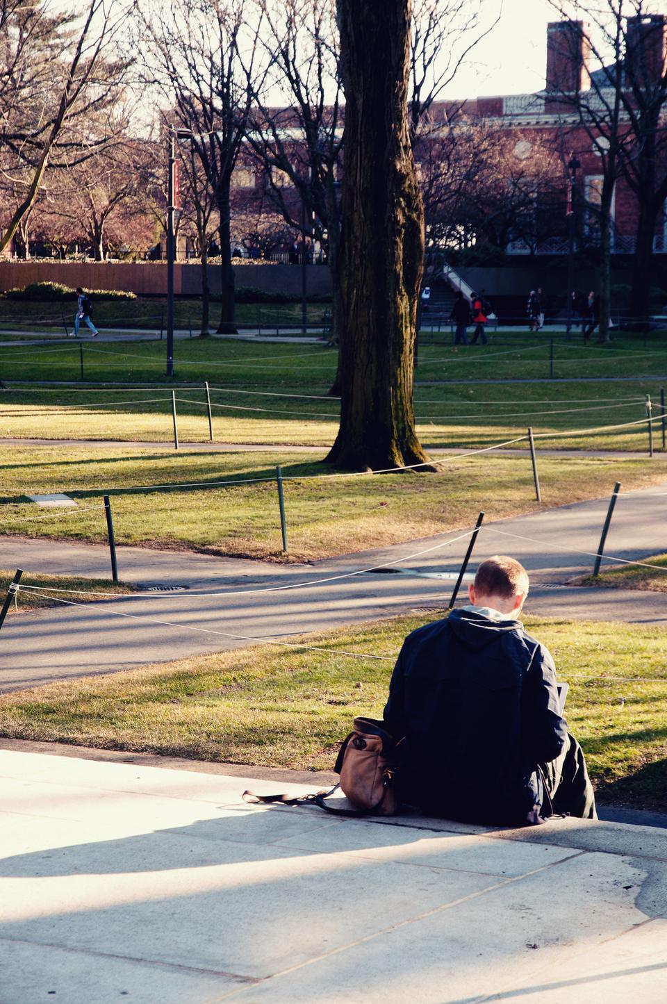 A student sits on the steps of the Holden Chapel, enjoying the good weather. 