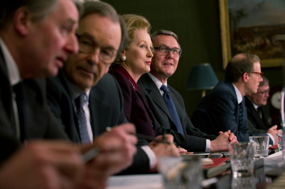 British Prime Minister Margaret Thatcher (Meryl Streep) confers with her cabinet ministers in the biographical film, “The Iron Lady,” directed by Phyllida Lloyd.
