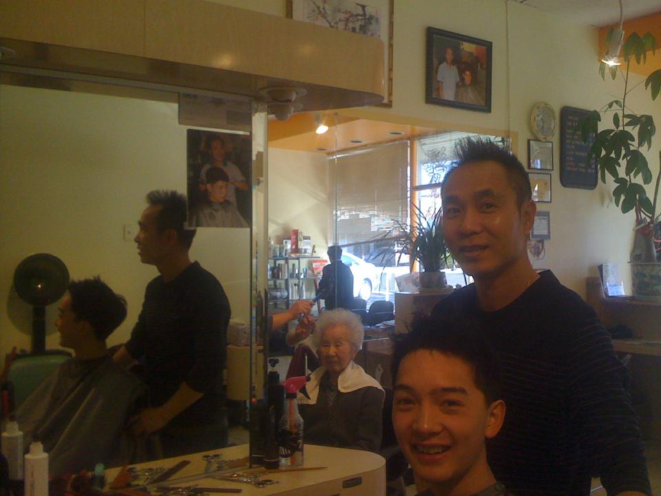 Flyby correspondent Brian C. Zhang getting a haircut; in background, framed image of Jeremy Lin at the same salon.