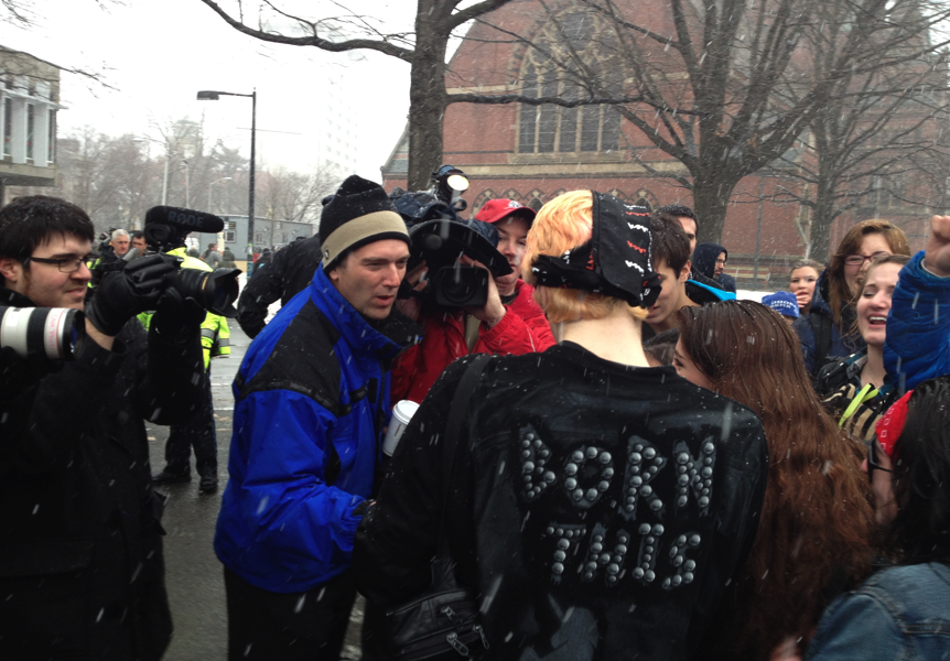 A fan in a "Born This Way" coat is interviewed by News outlets.