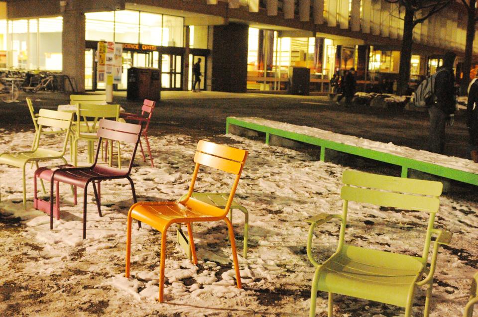 Colorful chairs sit artfully, and empty, in the snow on Friday evening, as they were too cold to sit on!