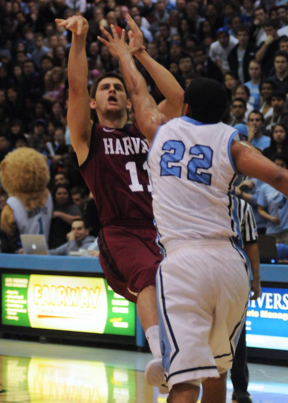 Co-captain Oliver McNally attempts a shot over Columbia’s Meiko Lyles during the Crimson’s 77-70 overtime win against the Lions on Friday at Levien Gymnasium. McNally finished with 12 points and four assists in 38 minutes of action. 
