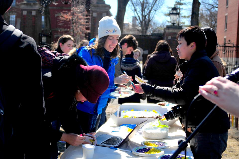 Members of  The Seneca, Inc. hand out pieces of yellow and purple cake  to students in front of the Science Center on Monday at the 2012 Women’s Week launch party. 
