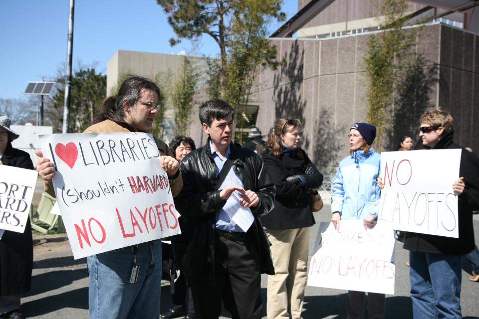 Students, faculty, and library staff assemble in front of the Science Center Tuesday to protest proposed cuts and layoffs in the library system.