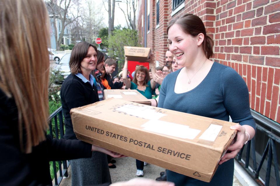 Patricia DiCarlo Fagioli carries the last box of decision letters to a waiting USPS truck. On Thursday morning, admissions office staff members formed an assembly line to mail 34,302 letters to applicants for the Class of 2016.