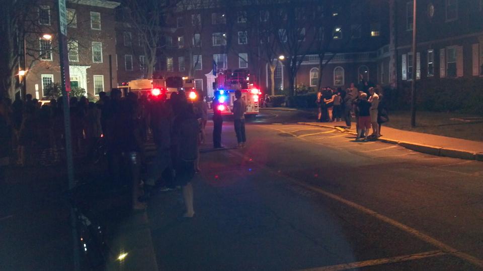 Firetrucks park outside of Eliot House while students, who were evacuated from the House for about half an hour early Sunday morning, mill nearby.