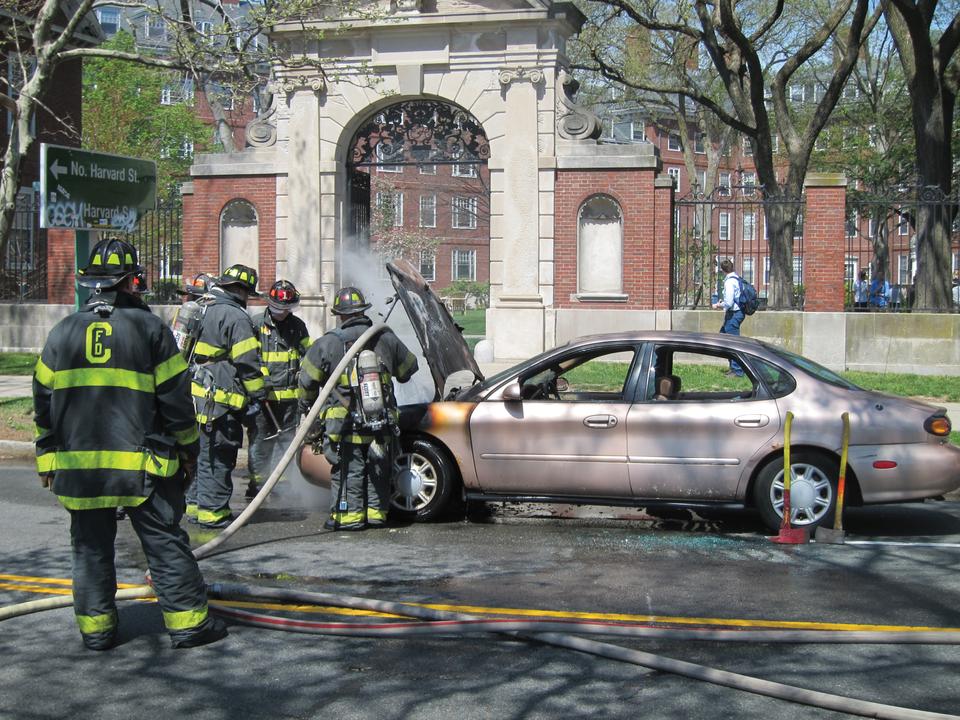 Firefighters work to extinguish a car which caught on fire in front of Elliot Courtyard on Wednesday afternoon.