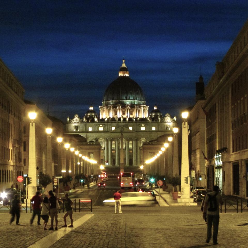 A street view of St. Peter's Basilica, the famed Renaissance church located within the walls of Vatican City, late at night.