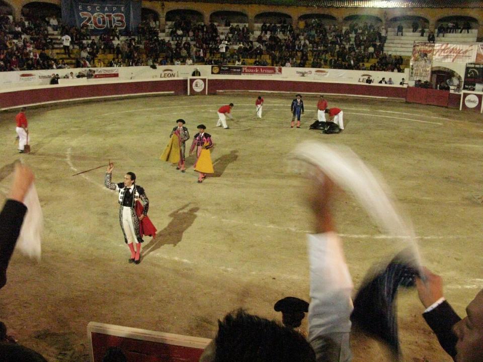 A triumphant novillero, or novice bullfighter, raises his sword at the Plaza de Toros Oriente in San Miguel de Allende, Mexico. Spectators wave handkerchiefs to implore the judges to grant the young man, Hector de Avila of Tenancingo, a severed bull’s ear as a trophy.
