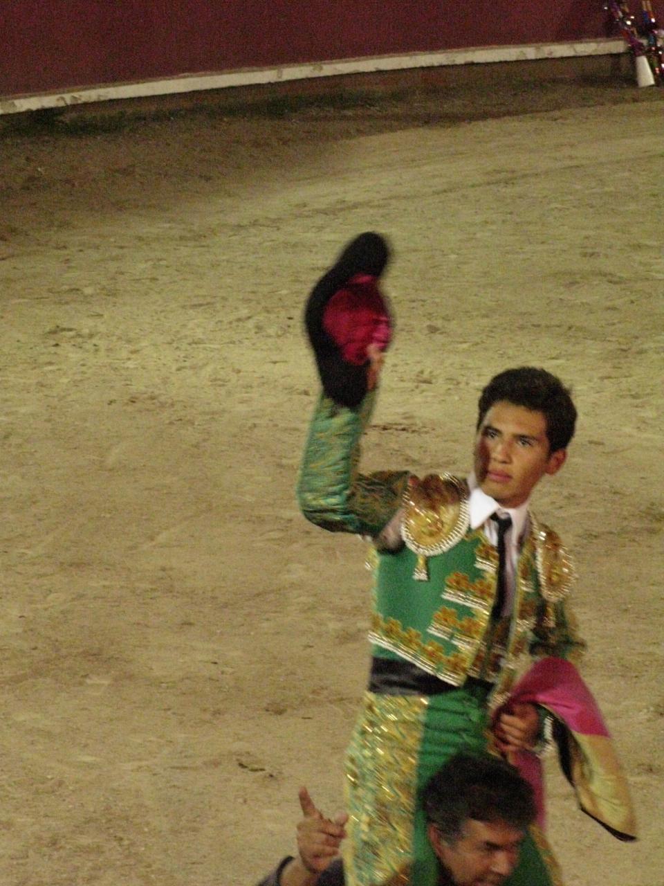 Francisco Martinez salutes the crowd as he rides out of the bullring on the shoulders of another man. Judges award a bullfighter a salida en hombros (literally “exit on shoulders”) if he performs exceptionally well.