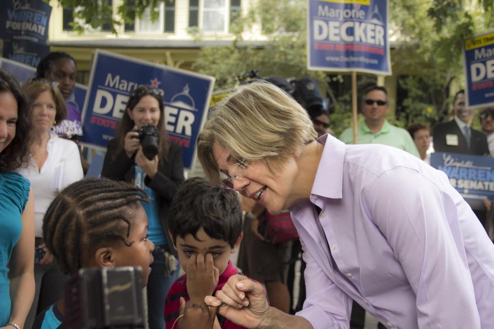 Elizabeth Warren is making a pinky promise with a Graham and Parks elementary student before voting in the state primary election. A Harvard Law Professor, she is currently challenging Scott Brown (R-MA) for his Senate Seat in the general elections.