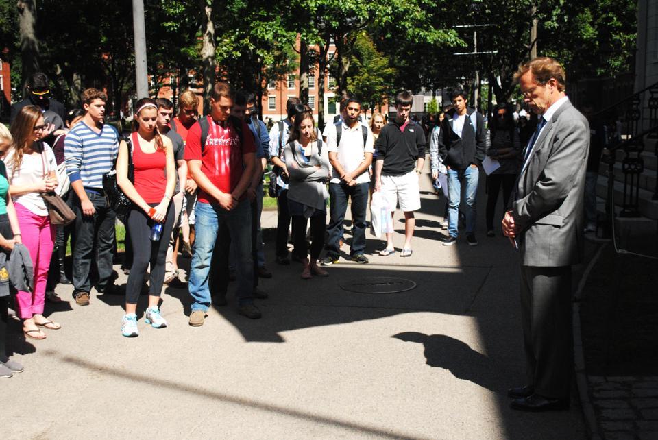 Dean of Freshmen, Tom Dingman, and students gather in the shadow of John Harvard and the American flag, as they remember the attacks on September 11, 2001 -  "Let us bow our heads in a moment of silence". 