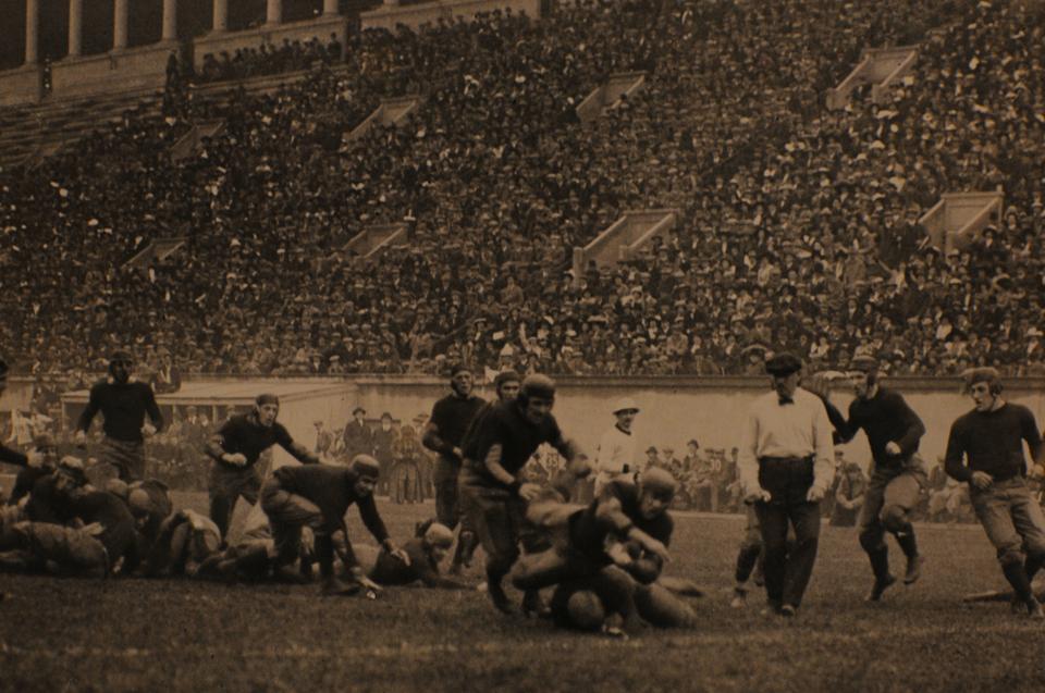 Before football as we now know it, the sport was a mixture of rugby and soccer. Pictured is the 1912 team playing in Harvard Stadium.