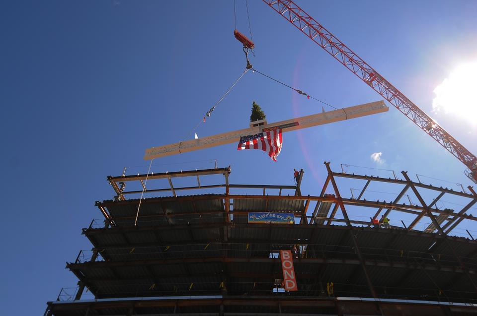 The highest steel beam of the new Tata building is hoisted above a crowd on the Business School campus on Monday. It was painted white and adorned with dozens of signatures and a small pine tree according to a Norse tradition adopted by steel workers in "topping off" ceremonies.