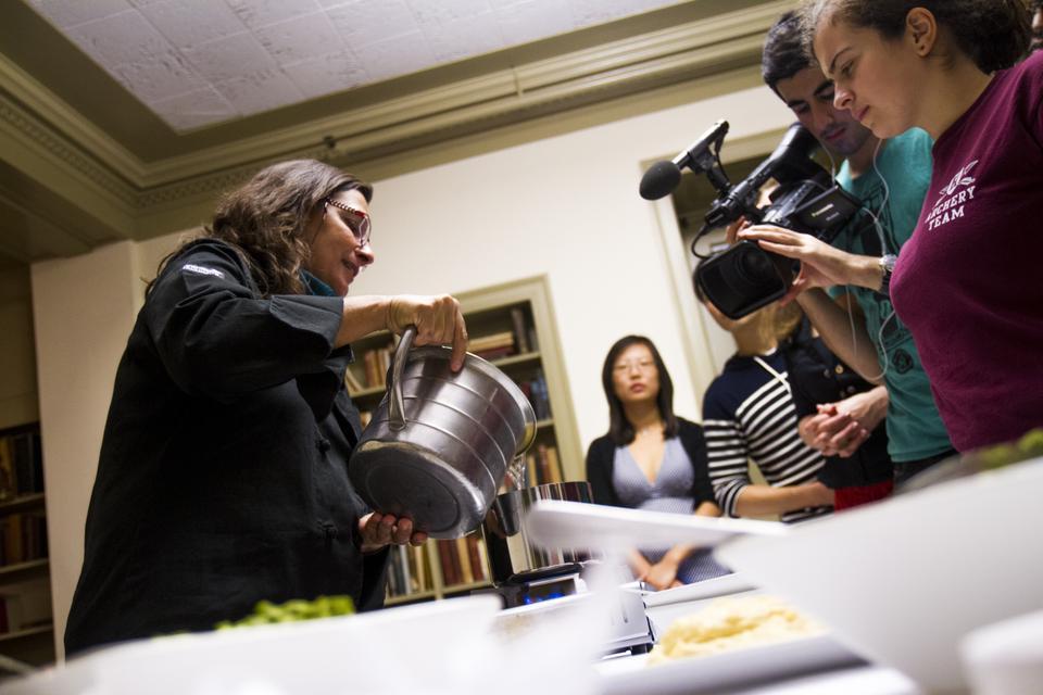 Diane Kochilas prepares Greek food while discussing transitions in Greek culinary traditions on Thursday. The free event, co-sponsored by Harvard University Dining Services and the Food Literacy Project, brought a packed crowd to Pforzheimer House's Hastings Room.
