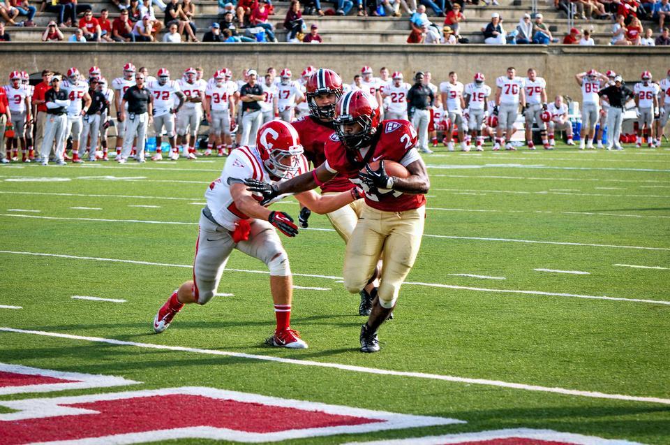 Senior running back Treavor Scales stiff-arms an oncoming Cornell safety in the Harvard football team’s 45-13 victory over Cornell on Saturday afternoon. Scales, who ran for 106 yards against the Big Red, leads the Ivy League in rushing yards per game (124.2) and rushing touchdowns (seven). 