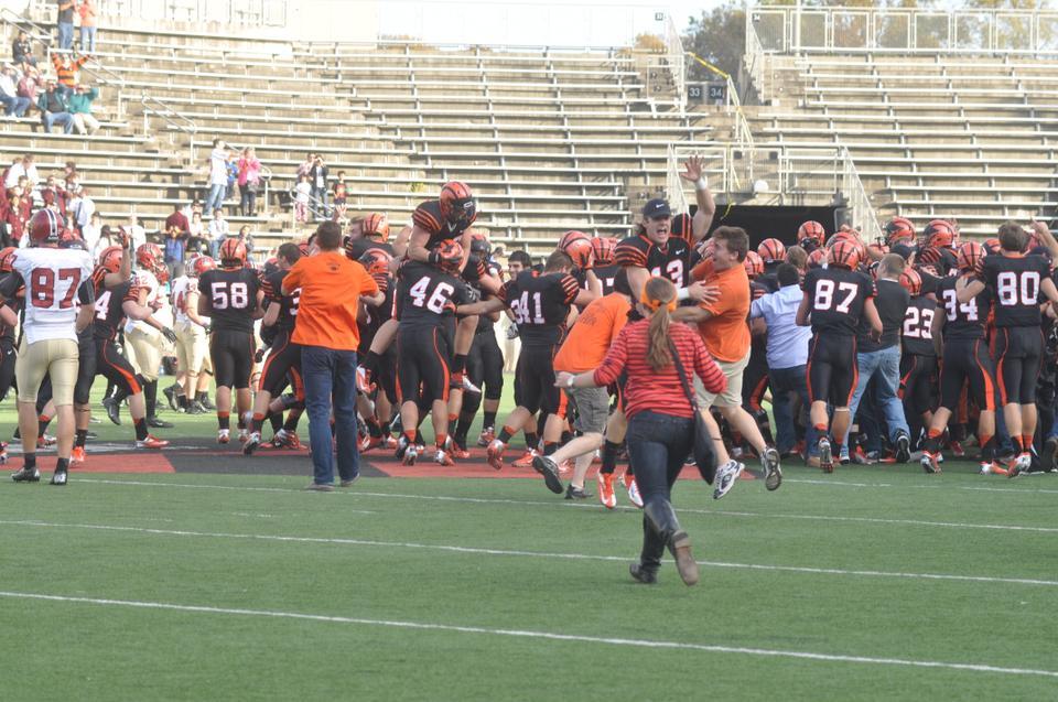 Princeton players celebrate as fans storm the field following the Tigers' shocking 39-34 upset over the Harvard football team on Saturday afternoon in Princeton, N.J.