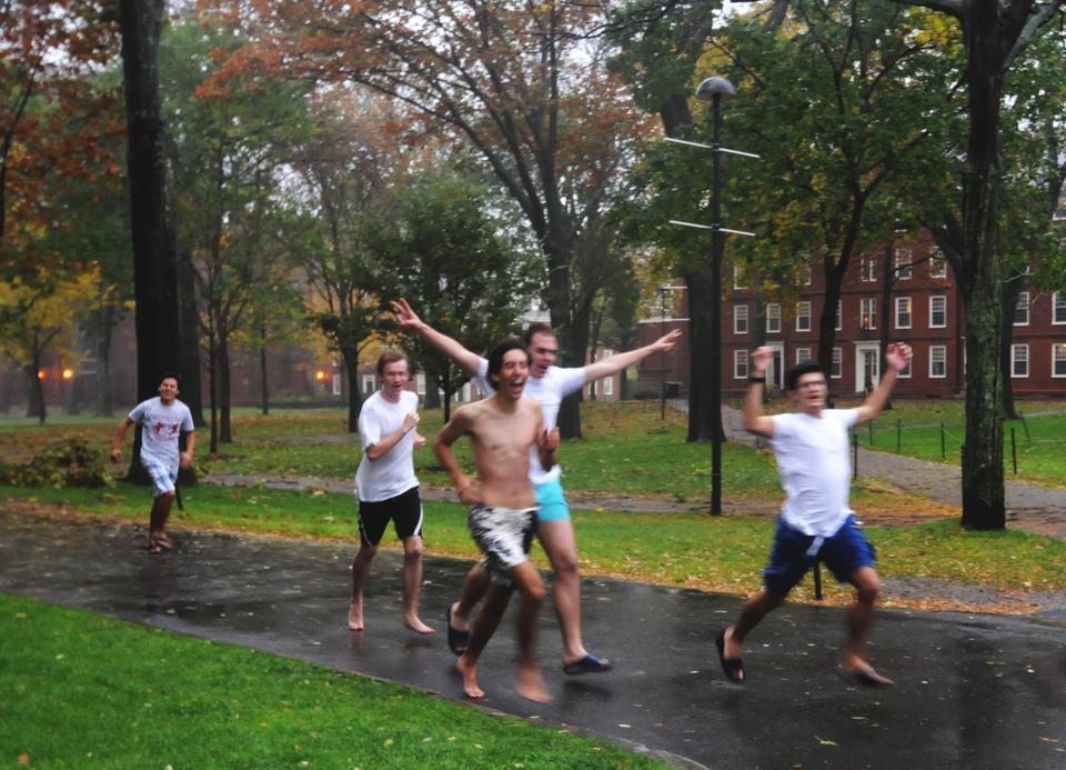 Students run through the Old Yard braving the weather of Hurricane Sandy. Due to high winds and rain many large tree branches and leaves were scattered throughout Harvard Yard, Tercentenary Theater, and the rest of Harvard Square.