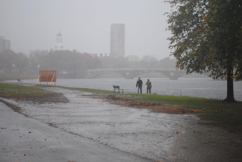 Pedestrians stop to watch Sandy over the Charles River, where the visibility is extremely low. 