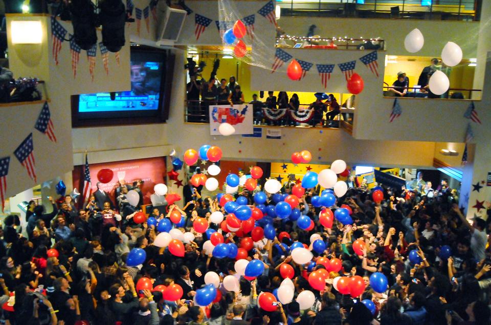 At 12:20AM after CNN released their projection that Obama had won the Presidential election, dozens of balloons drop onto spectators below at the Kennedy School's IOP election watch party.
