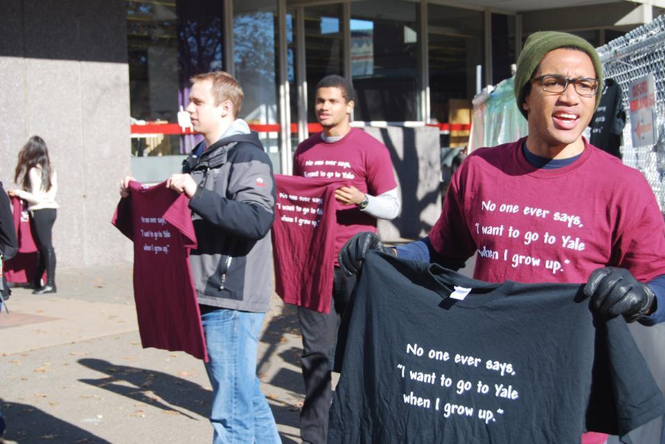Harvard Seniors, from left to right, Chris H. Weber, Andreas M. Haggerty, and Hilton H. Augustine, sell t-shirts outside the science center Wednesday afternoon for The Game against Yale this coming Saturday. 