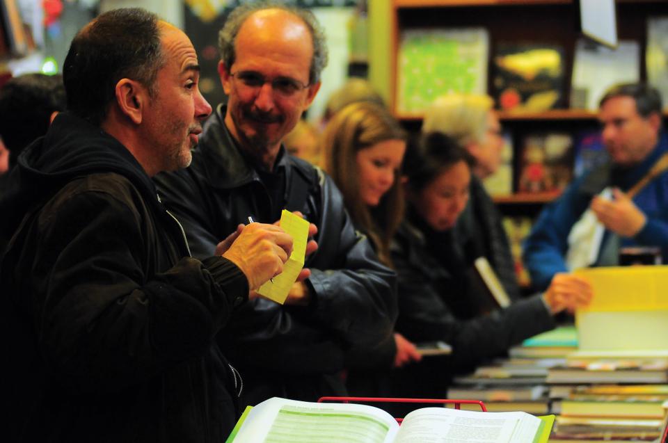 Harvard Book Store patrons share stories about their experiences with the longterm Harvard Square fixture on Thursday evening at the store’s 80th Birthday Party. Visitors browsed the collections and sipped apple cider.