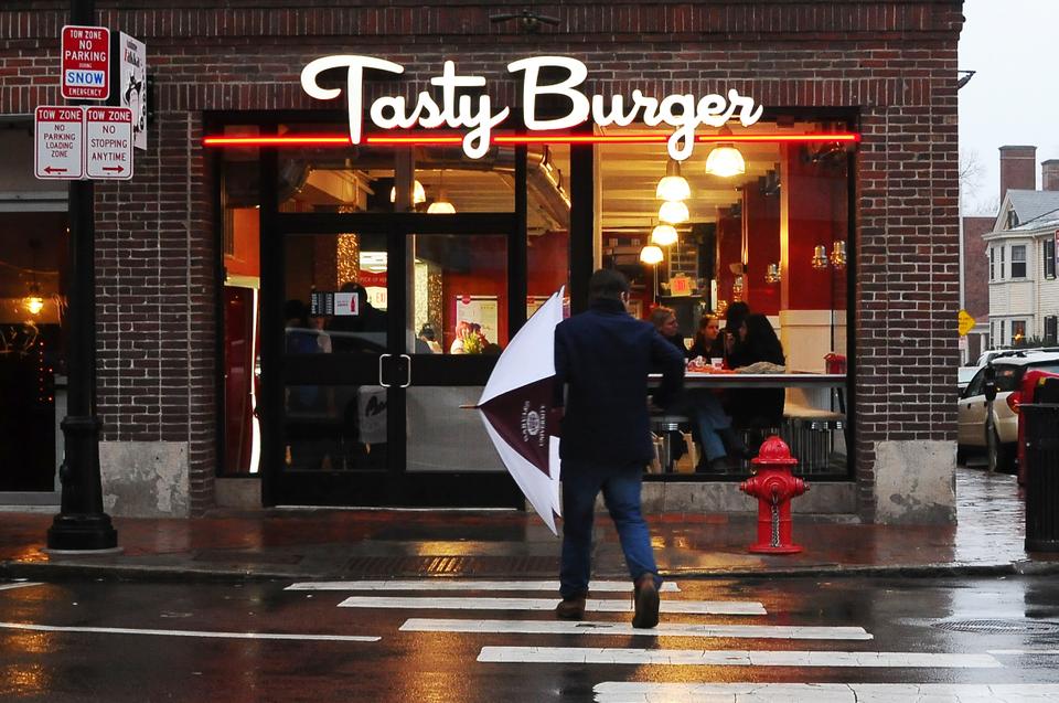 Customers step out of the rain and into Tasty Burger on the restaurant's opening day in the Square. 