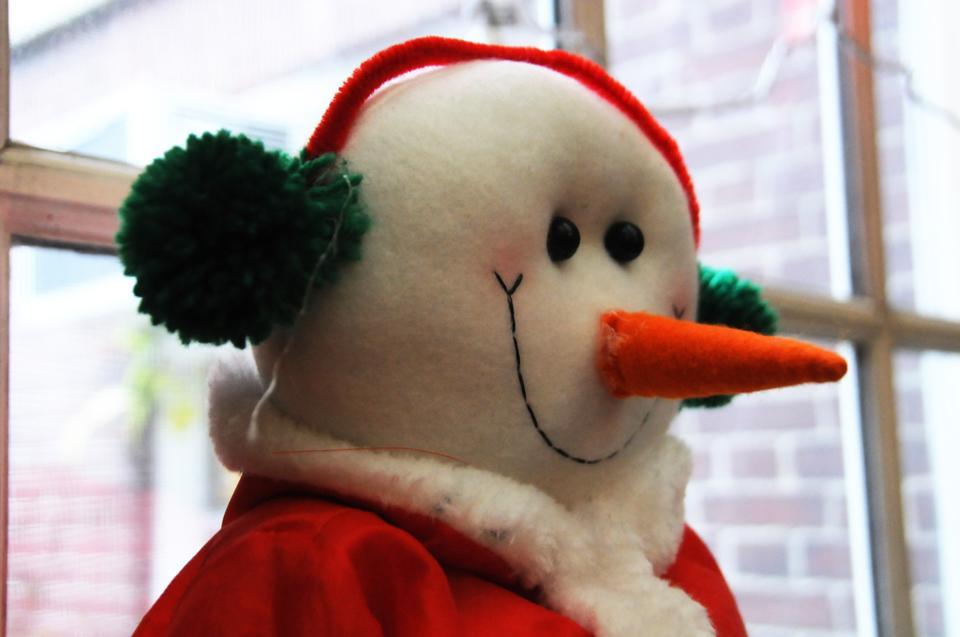 A snowman sits in a window near the Adams dining hall.