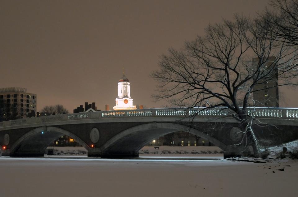 Snow blankets the Charles River and the newly restored John W. Weeks Footbridge in Cambridge on Monday evening. The river was completely frozen over after snow began to fall in the afternoon.