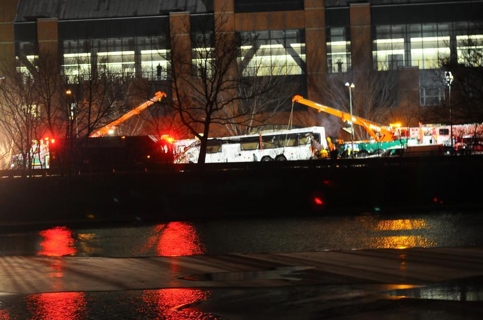 Cranes surround a damaged charter bus, which crashed on Saturday evening, injuring more than 30 people.