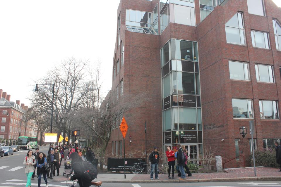 Students and pedestrians gather outside the Belfer Center of the Harvard Kennedy School, which was evacuated earlier today.