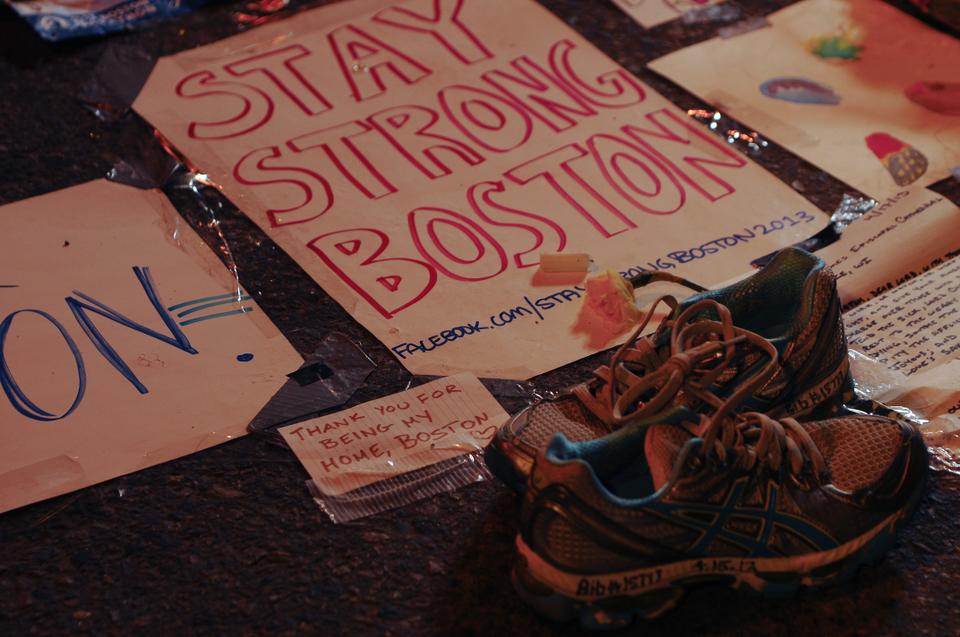 Many people brought signs; flowers; and other tokens to a memorial set up at the barrier on the intersection of Boylston and Berkley Street; just a few blocks beyond the marathon's finish line. These shoes were brought by Lisa Mara, a Bostonian runner who finished fifteen minutes before the blasts. Other items included a marathon medal, candles, and numerous handwritten letters.