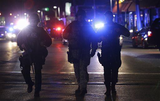 Officers wearing tactical gear arrive in Watertown on Friday, April 19, 2013. Reports of explosives being detonated and police are telling reporters to turn off their cell phones. Dozens of officers and National Guard members are in Watertown, where television outlets report that gunfire and explosions have been heard. 