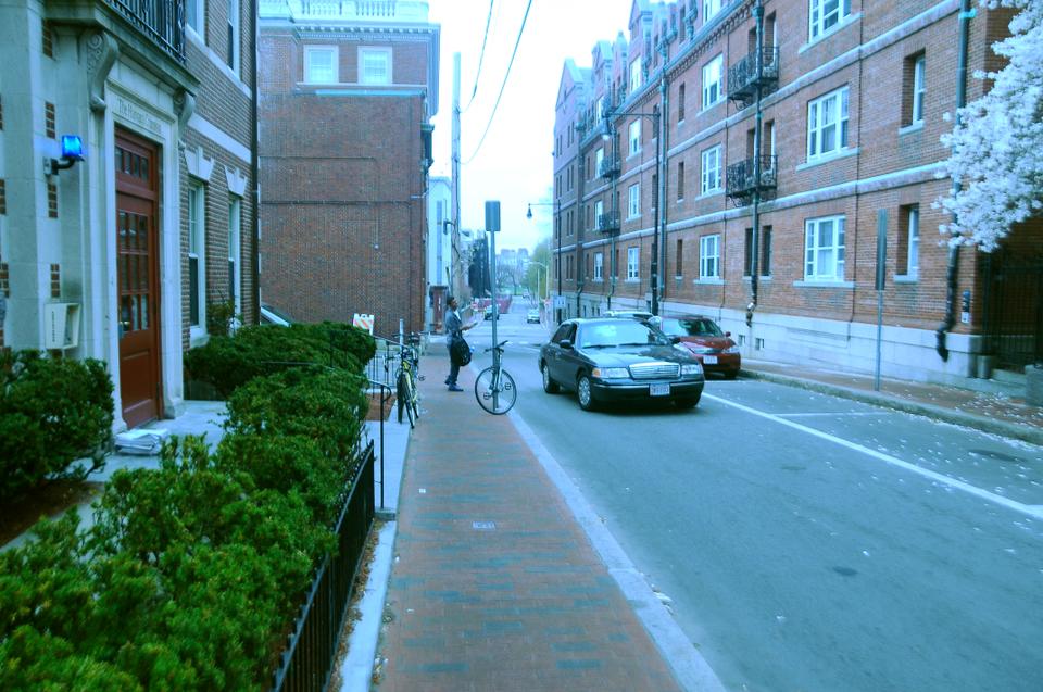 Police officers in an unmarked vehicle stop to check on a Harvard student walking on Plympton Street Friday morning. Harvard, along with other local universities, canceled classes on Friday in response to the ongoing manhunt for a suspect in the Boston Marathon bombing.