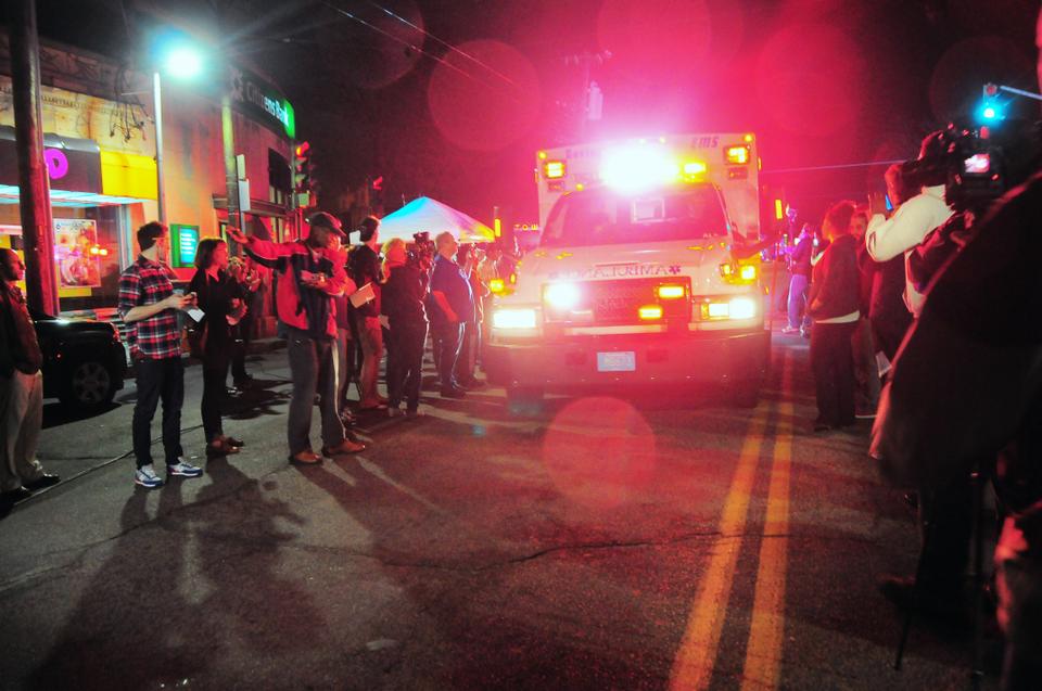 Assembled crowds cheer as an ambulance passes by on Mt. Auburn Street after its departure from the scene where Boston Marathon bombing suspect Dzokhar Tsarnaev was apprehended by police on Friday evening. Bystanders cheered "USA! USA!" as police and fire vehicles exited the perimeter of the scene