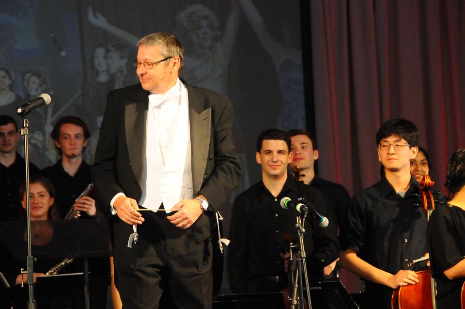 Dr. N. Gregory Mankiw prepares to take a bow with the River Charles Ensemble on Saturday afternoon on the Science Center Plaza. Dr. Mankiw was joined by members of the Hasty Pudding Theatricals to depict a colorful rendition of Beethoven's Fifth Symphony for Arts First Weekend.