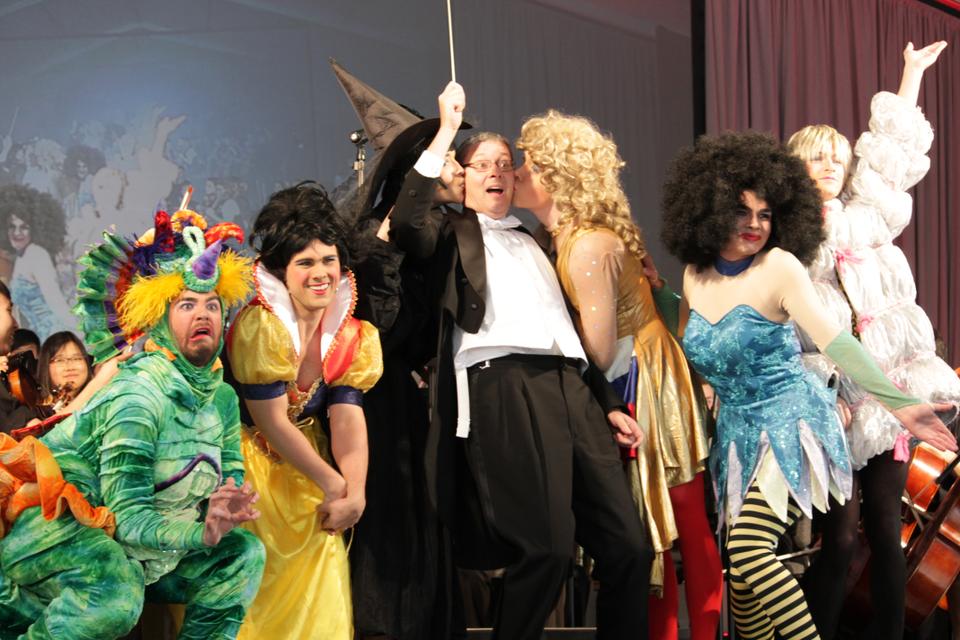 Economics 10 professor N. Gregory Mankiw (centre) is kissed by members of the Hasty Pudding Theatricals as he conducts the River Charles Ensemble as part of Harvard's Arts First Weekend on Saturday. Daniel J. Hilhorst