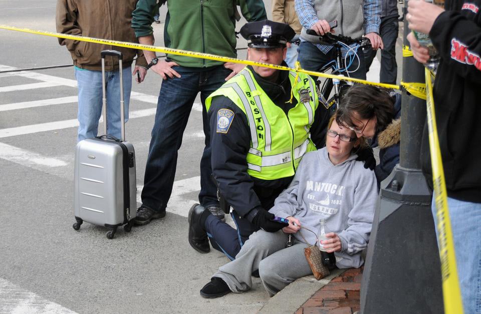 A Boston Police Department officer comforts a shocked onlooker of the bombings in Copley Square.