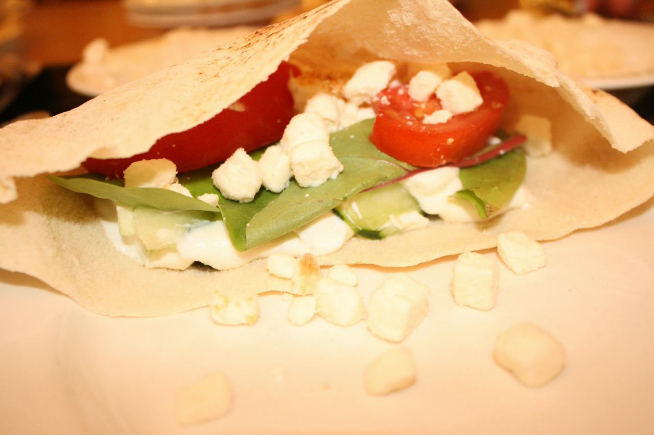Place tomato wedges and feta inside pita on top of the yogurt