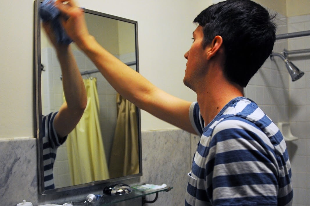 Grant A. Sprow '16 cleans a mirror in freshman dorm Apley Court as part of routine Dorm Crew duties. Sprow has participated in Dorm Crew since his freshman fall.