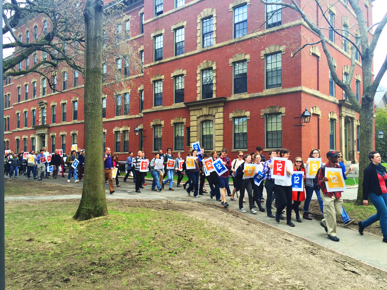 Supporters of the Harvard Teaching Campaign proceed through the Yard before submitting a petition to cap section sizes at 12 students to Massachusetts Hall. 