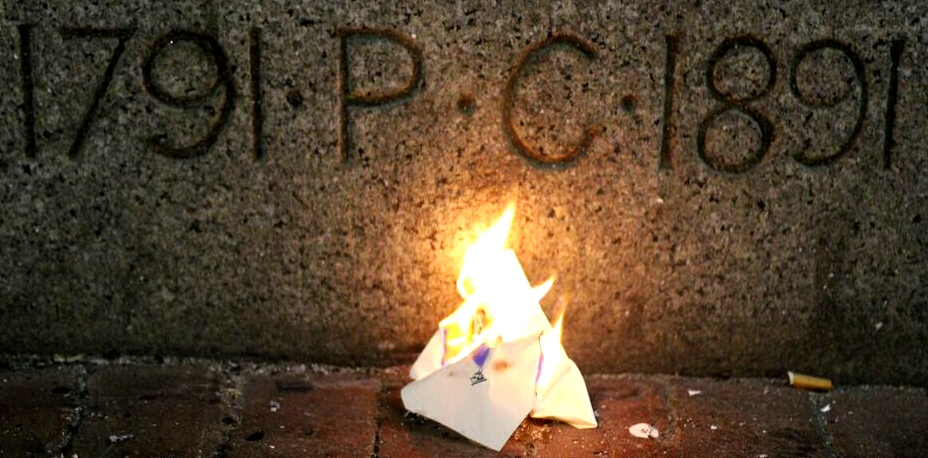 A Porcellian Club punch invitation burning in front of the club's building.