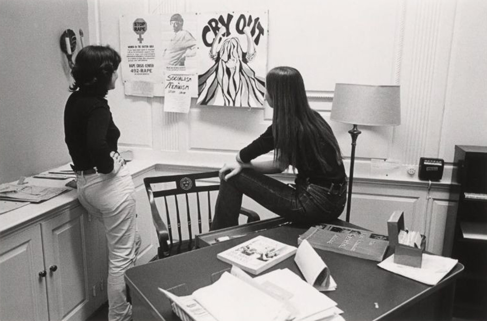 Women observe posters and artwork at the Women's Center in 1975. 