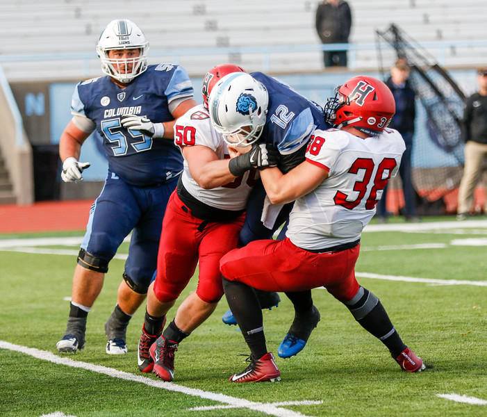 The duo of junior defensive tackle Richie Ryan (50) and senior linebacker Alex White (38) lock down Columbia senior quarterback Anders Hill. In the final moments of the game, the Crimson held off a potential game-tying play from the Lions as Hill's pass went incomplete. 