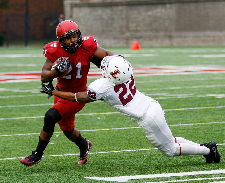 Harvard junior running back Charlie Booker III holds off Lafayette senior defense back Phillip Parham. Booker is a graduate of Cypress Ranch High School in Texas.