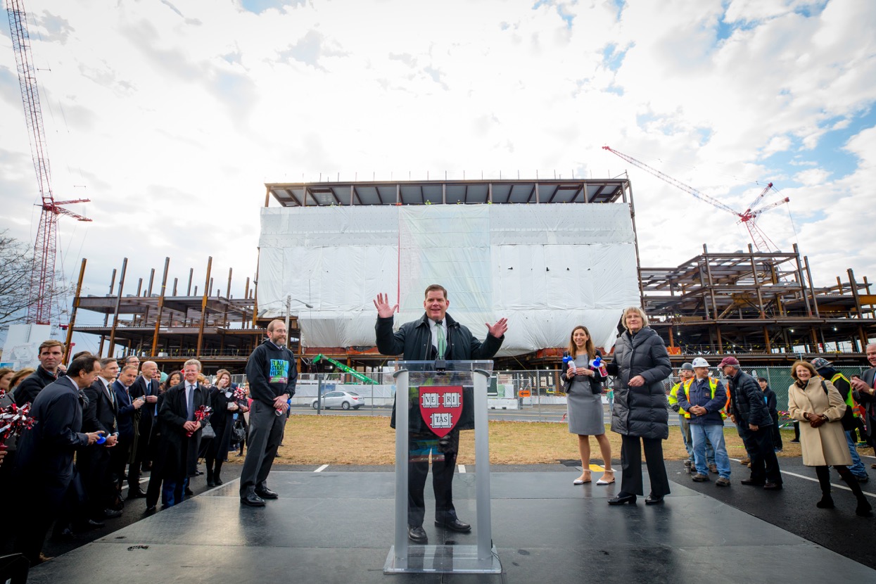 Harvard Provost Alan M. Garber ’77, Mayor Martin J. Walsh, and President Drew G. Faust stand against the backdrop of the Science and Engineering Complex’s completed steel framework.