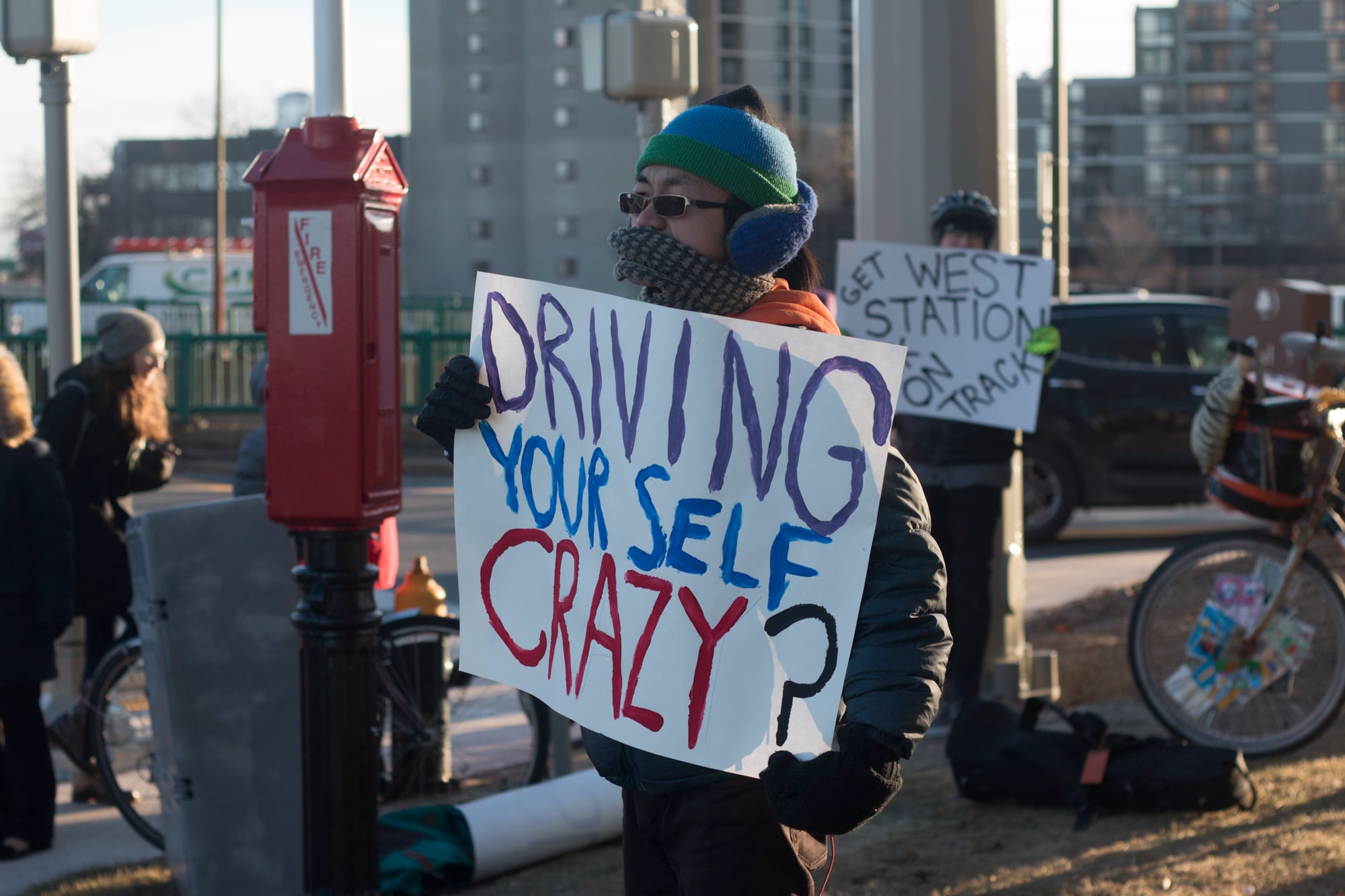 Protesters at the "Transit Not Traffic" rally try to catch the attention of commuters in Allston.