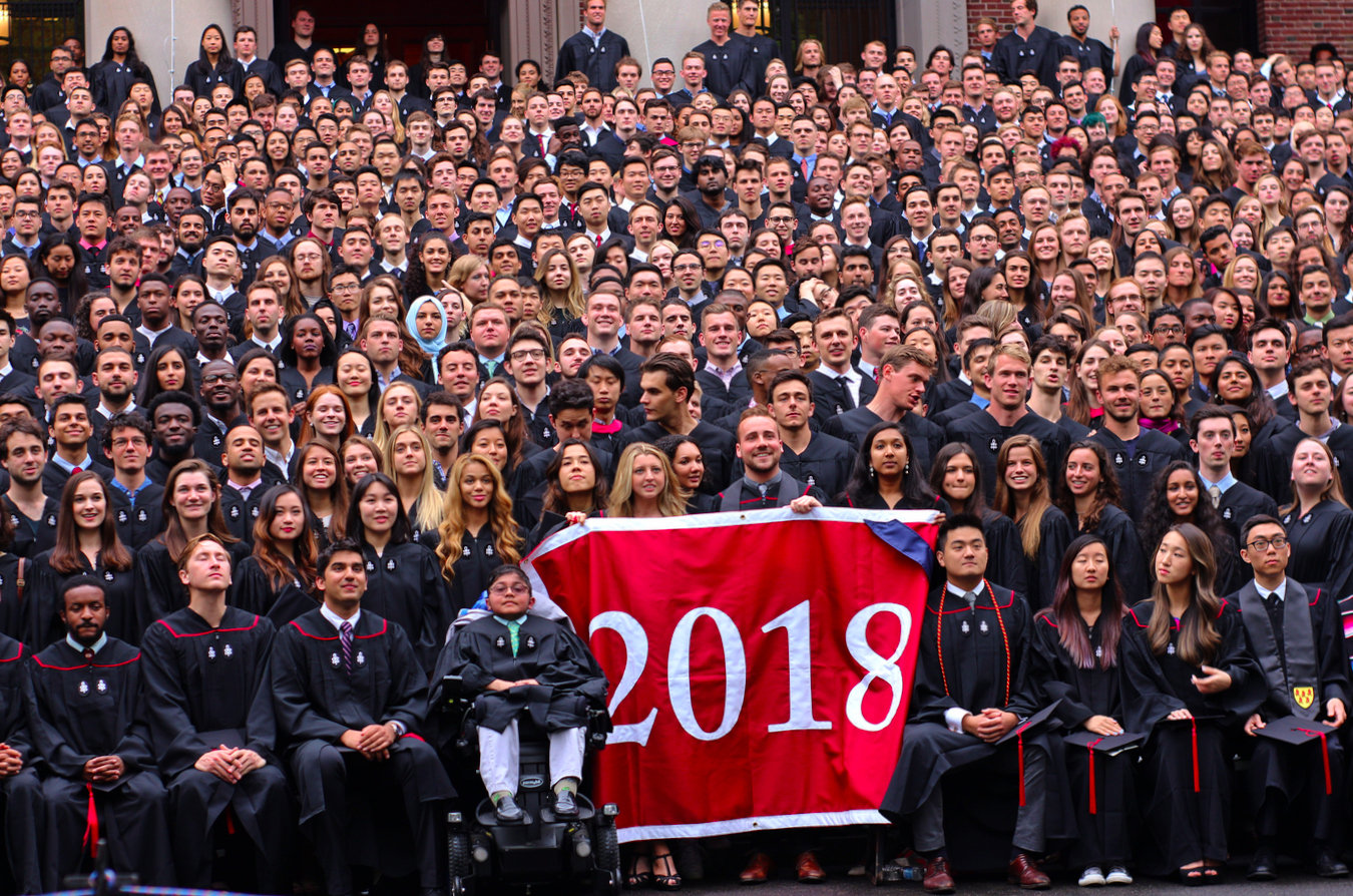The Class of 2018 pose for a class photo on the steps of Widener library. 